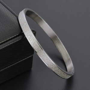 Détail du bracelet en acier titane argenté montrant une texture givrée et brossée
