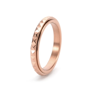 Detailed side view of rose gold spinning fidget ring with pyramid studded texture