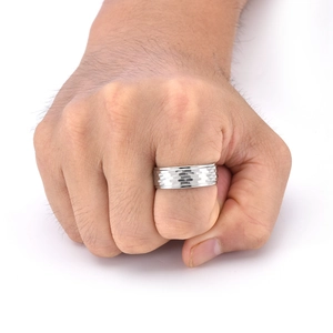 Macro detail of men's wide silver ring with hammered texture and polished edge on finger
