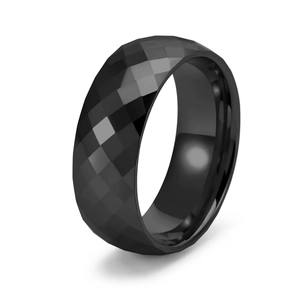 Detail of faceted black tungsten ring showing multi-angle light reflections and polished finish