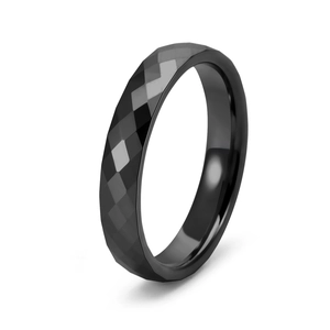 Detail view of faceted black tungsten ring showing geometric diamond cut surface