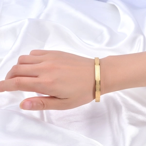Détail d'un bracelet en acier titane plaqué or rose 18K givré sur fond de soie blanche