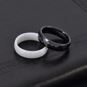 Minimalist faceted ceramic ring pair in black and white with reflective diamond cut
