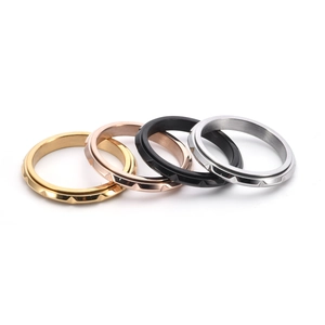 Macro shot of four ultra-slim rotatable fidget rings in gold, rose gold, black and silver