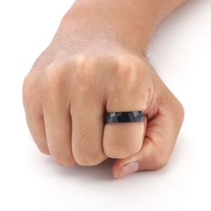 Détail d'une bague pour homme en tungstène noir avec motif à facettes géométriques