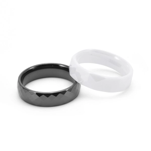 Macro view of geometric faceted black and white ceramic rings set on white background