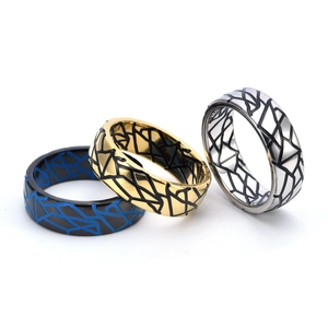 Detail of three vintage cracked pattern rings in black, gold, and silver stainless steel