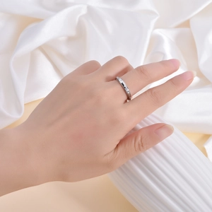 Close-up of 3mm thin silver ring with star engraved pattern on hand with silk backdrop
