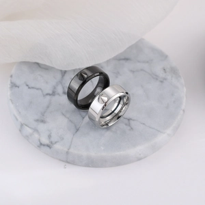 Macro shot of punk style stainless steel rings with sharp cone studs on marble base