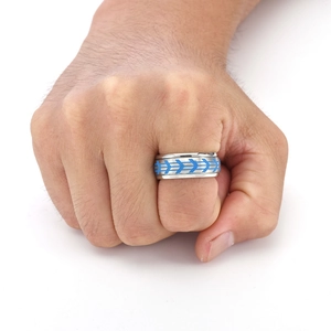 Macro shot of silver titanium ring featuring blue arrow tyre pattern for men