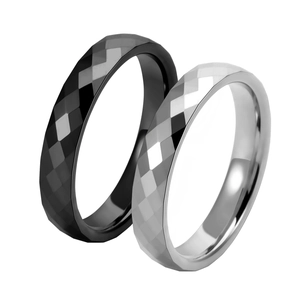 Detail of couple rings featuring geometric diamond cut patterns in black and silver finishes
