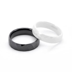 Set di anelli in ceramica bianchi e neri con superfici geometriche sfaccettate e lucide