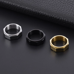 Macro detail of rotating nut rings in silver, black, and gold colors with brushed texture