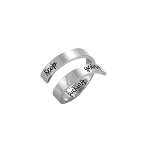 Macro shot of polished stainless steel spiral ring with Keep Fucking Going engraving