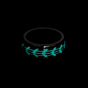 Macro shot of black titanium spinning ring with glowing green geometric tire patterns