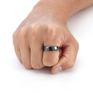 Primo piano di un anello da uomo in ceramica nera sfaccettata con superfici geometriche