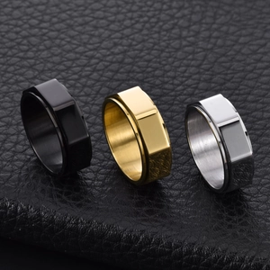 Detailed view of rotating octagon titanium rings in black, gold, and silver finishes