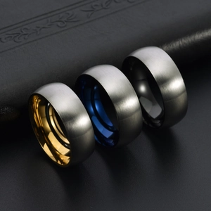 Three matte brushed stainless steel rings with gold, blue and black polished inner bands