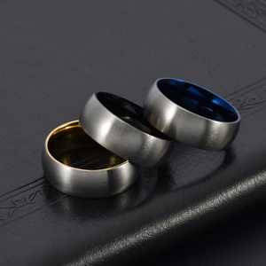 Macro shot of three brushed titanium rings with gold, blue, and black inner plating