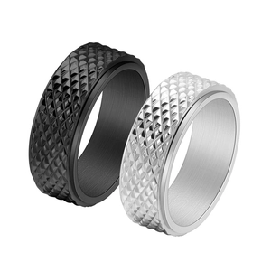 Close-up of diamond-cut textured patterns on black and silver titanium steel rings