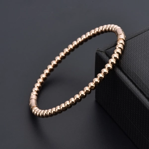 Elegant rose gold beaded bangle bracelet for women featuring a minimalist polished metal design