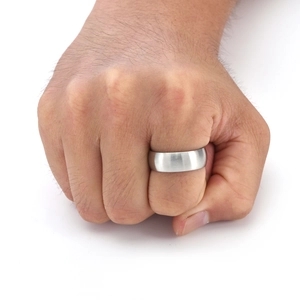 Macro shot showing the brushed metal texture and wide band detail of a men's steel ring