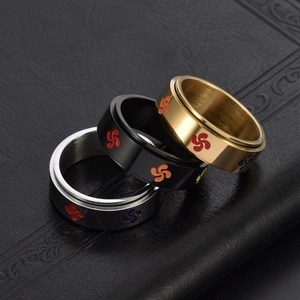 Three rotatable titanium steel rings in gold, black, and silver with cross patterns