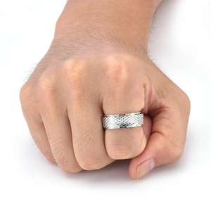 Close-up of wide silver titanium ring with diamond knurling texture on male model hand