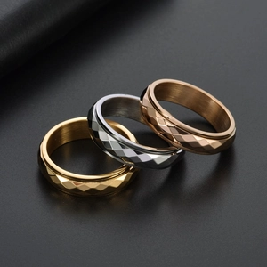 Rotating stainless steel rings set in gold, silver, and rose gold with diamond-cut faces