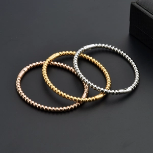 Detailed view of three-tone bead bracelets in gold, silver, and rose gold finishes