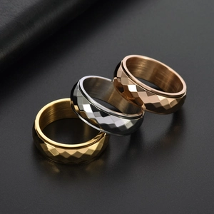 Close-up of geometric rotating steel rings in gold, silver, and rose gold finishes