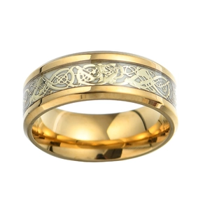 Macro shot of gold plated men's ring with white inlaid Celtic dragon pattern detailing