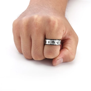 Close-up of rotatable spinner ring for men with brushed finish and religious mantra engraving