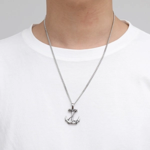 Collier homme pendentif ancre rétro en acier titane avec détails corde sur t-shirt blanc