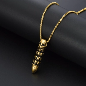 Close-up of gold bullet pendant with skull reliefs on a punk style box chain necklace