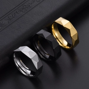 Detail shot of 6mm faceted tungsten rings in silver, matte black, and gold finish