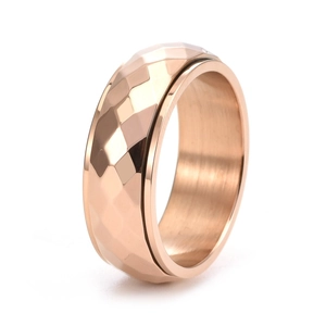 Detailed view of rose gold spinning ring with geometric diamond-cut faceted surface