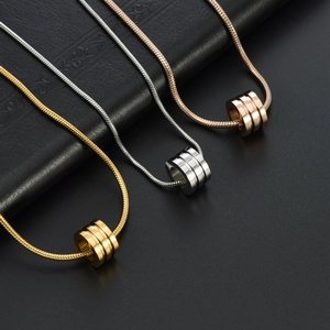Three cylindrical titanium steel pendant necklaces in gold, silver, and rose gold finishes