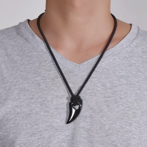 Men's black horn pendant necklace in wolf tooth style with woven rope on a model