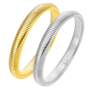 Detail of gold and silver Tubogas stretch bracelets with ribbed stainless steel texture