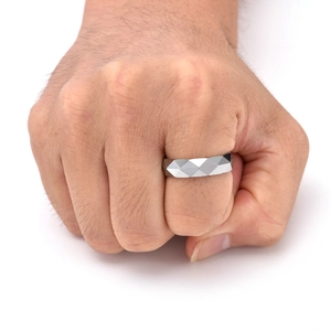 Primo piano di un anello da uomo in tungsteno argento con sfaccettature geometriche a rombi