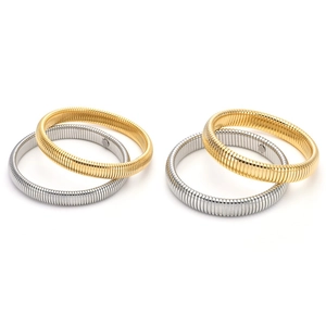 Macro detail of gold and silver Tubogas stretch bracelets with ribbed metal texture