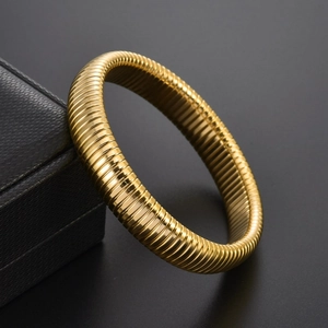Macro detail of 18K gold plated stainless steel bracelet with textured ribbed pattern