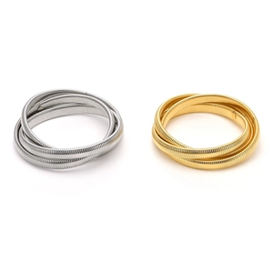 Dettaglio di bracciali a serpente tubogas oro e argento con finitura metallica lucida
