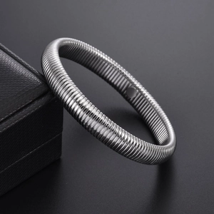 Polished silver stainless steel spring bracelet on premium black leather jewelry display