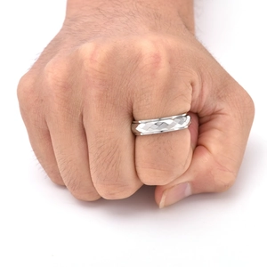 Macro view of rotating spinner ring with geometric diamond-cut facets in silver titanium steel