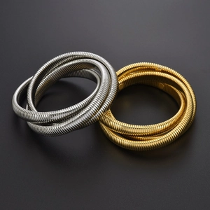 Dettaglio di bracciali a serpente a tre strati intrecciati in oro e argento lucido
