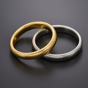 Detailed view of elastic striped steel bracelets in gold and silver mirror finish