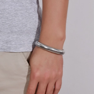 Close-up of flexible silver titanium steel snake bone bracelet with ribbed metal texture