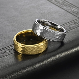 Unisex hammered tungsten steel rings in gold and silver finish on black leather surface